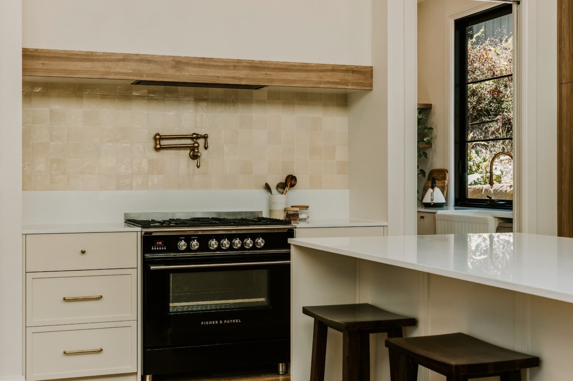 Yandala kitchen with zellige tile splashback, timber rangehood and Fisher & Paykel oven.